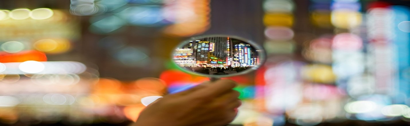 City lights focused in magnifying glass