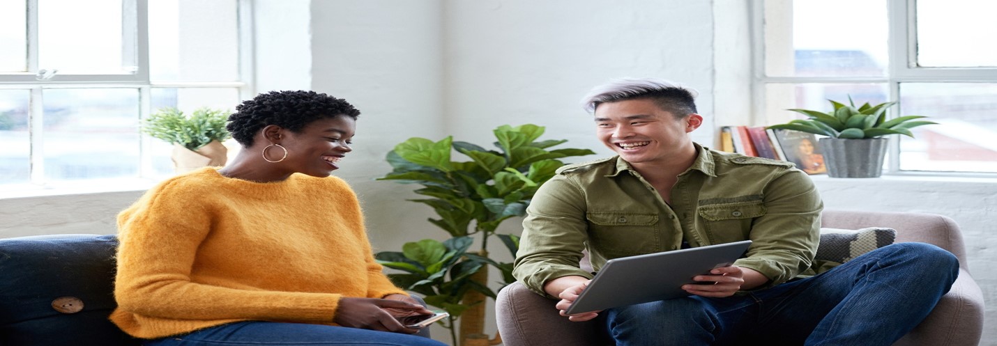 Two smiling people looking at tablet