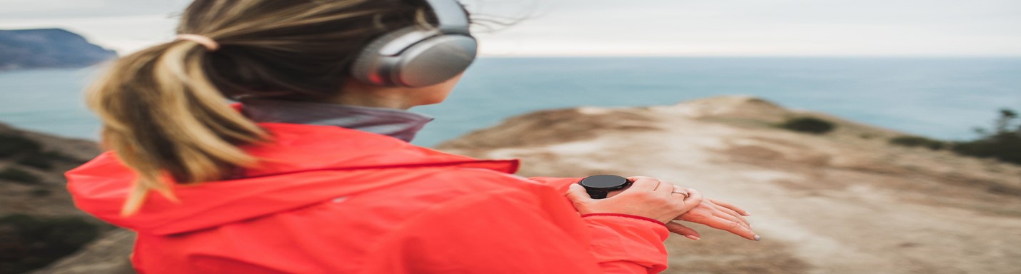 Person in headphones checking smartwatch