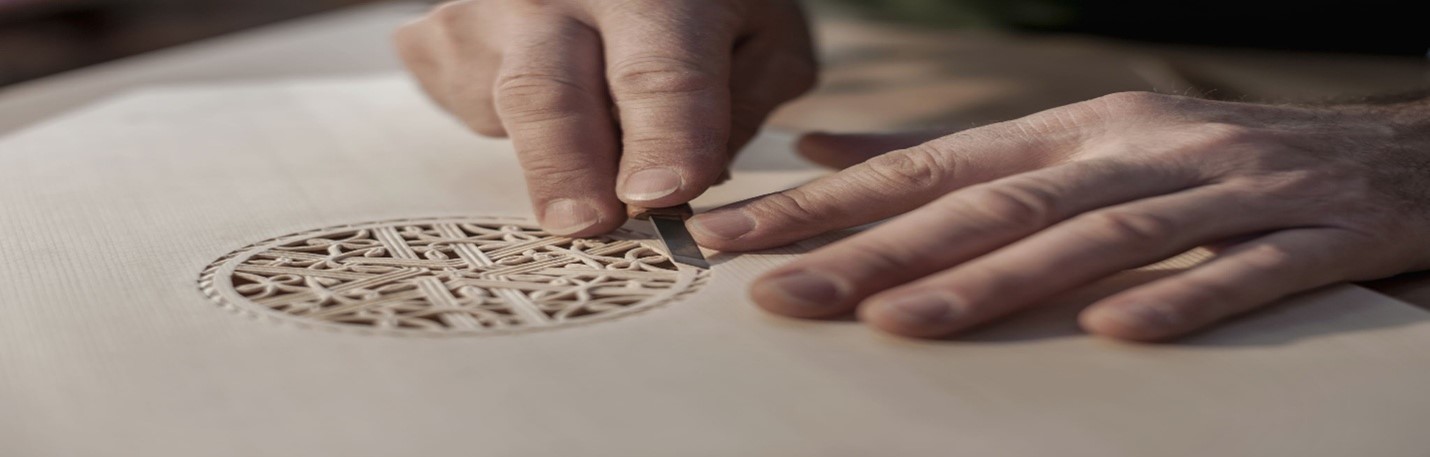 Person carving detailed ornament out of wood