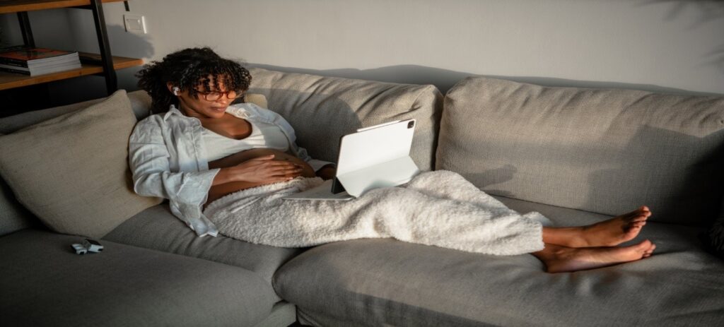 Person lying on sofa with laptop