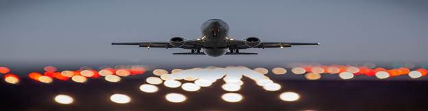 Airplane taking off with city lights in background