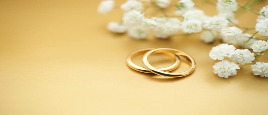Gold wedding bands and white flowers
