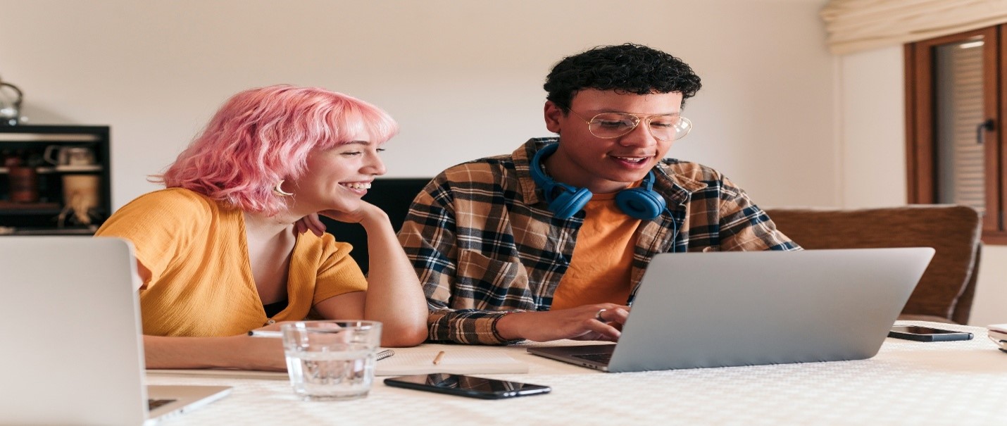 Two people using laptop