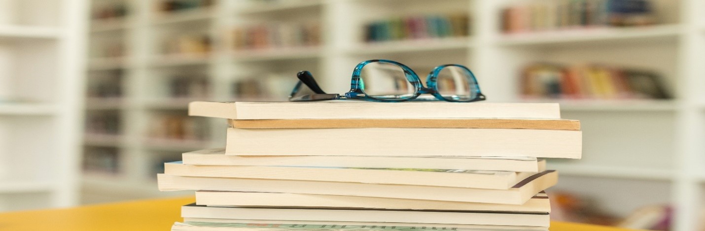 Eyeglasses resting on stack of books